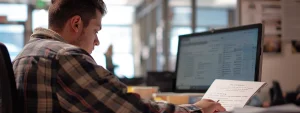 a person filling out paperwork on a computer for sam registration.